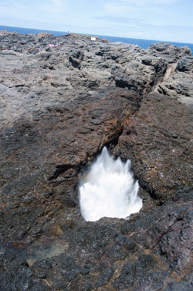DSC_8168.jpg - A blow hole ... air gets compressed in a cavern underneath the rocks by water flowing in, and then pushes it back out through a hole at the stop, resulting in something geiserie